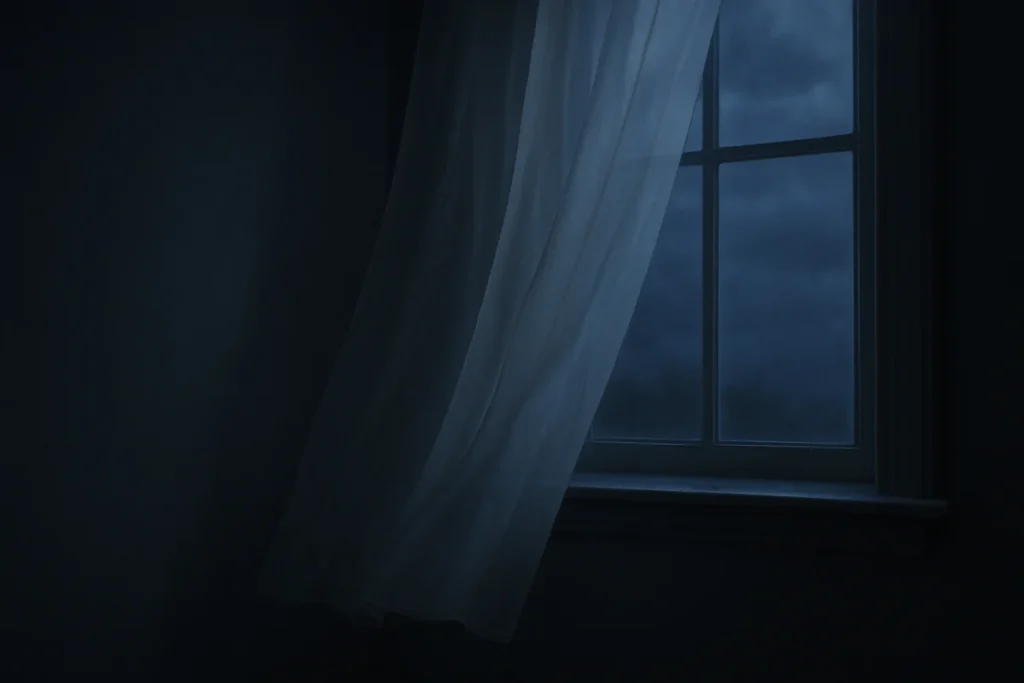 夜の室内、薄く揺れる白いカーテンと窓辺の静かな景色